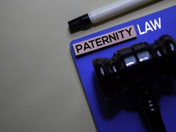 Paternity Law text on sticky notes and gavel isolated on office desk. Justice law concept