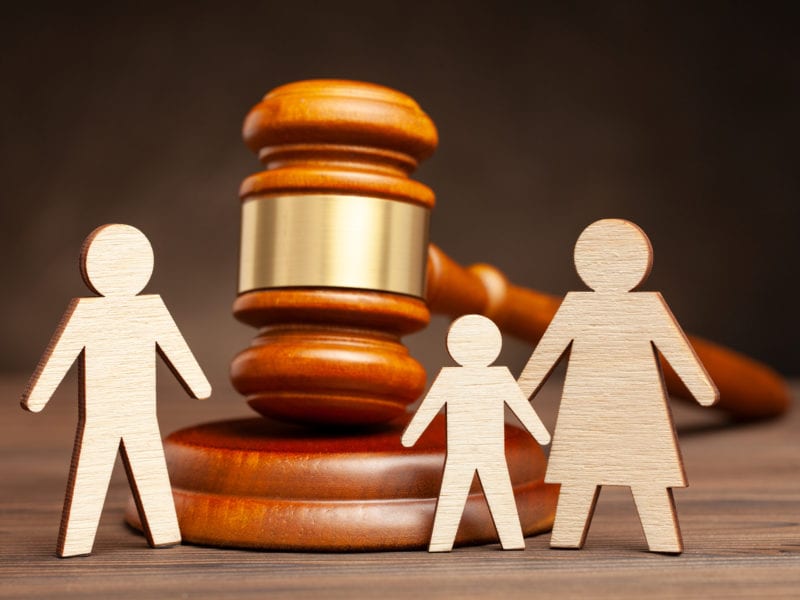 Deprivation of the parental rights of the Father. The law protects children from dad violence. Mother with child apart from father and judge's hammer