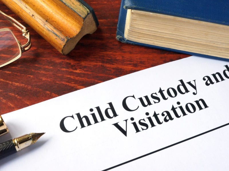 Child Custody and Visitation written on a paper and a book.